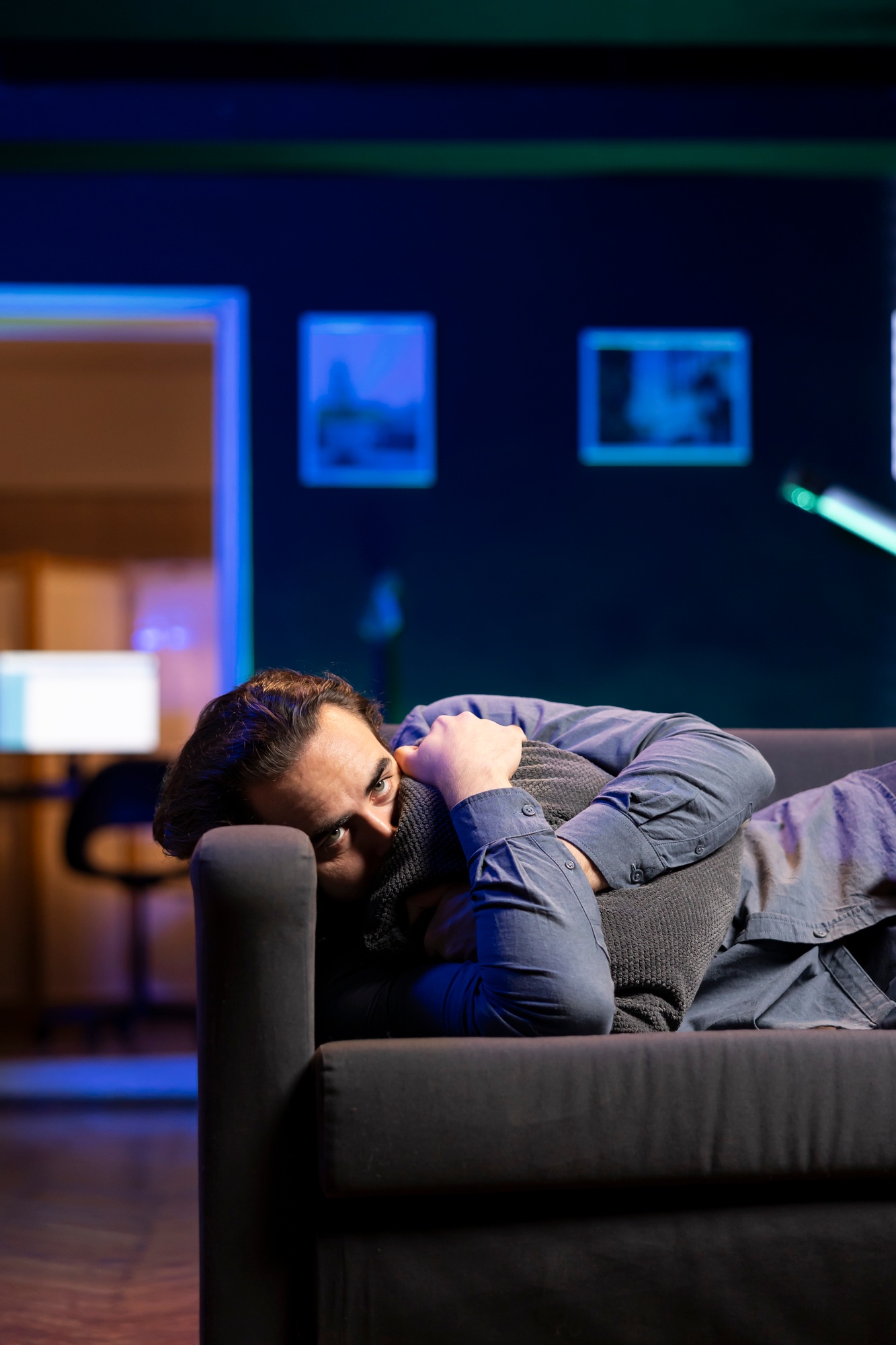 Person laying down hugging pillow seeing sad show, looking for emotional comfort